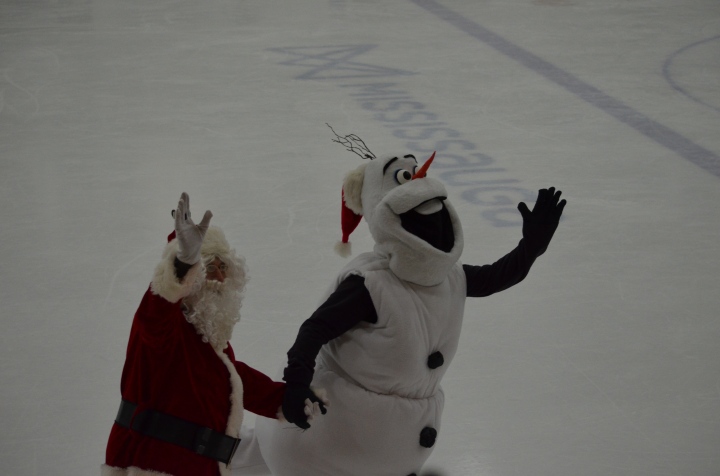 Santa and Olaf skating hand in hand.
