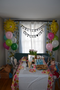 Violet at her party table. Banner Reads: `Forever Home. Gotcha Day`
